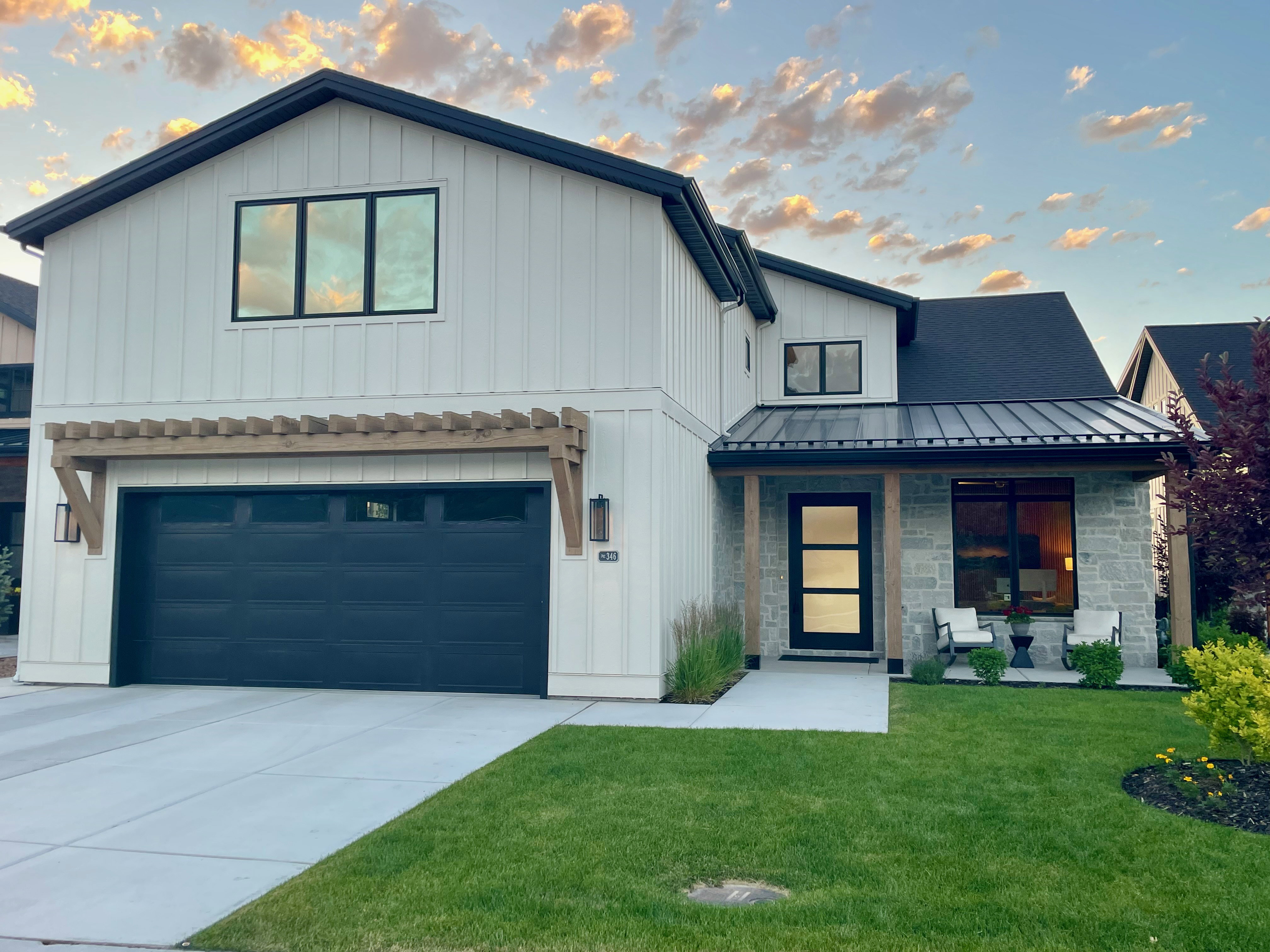 Modern farmhouse exterior featuring white board and batten siding and a dark metal roof