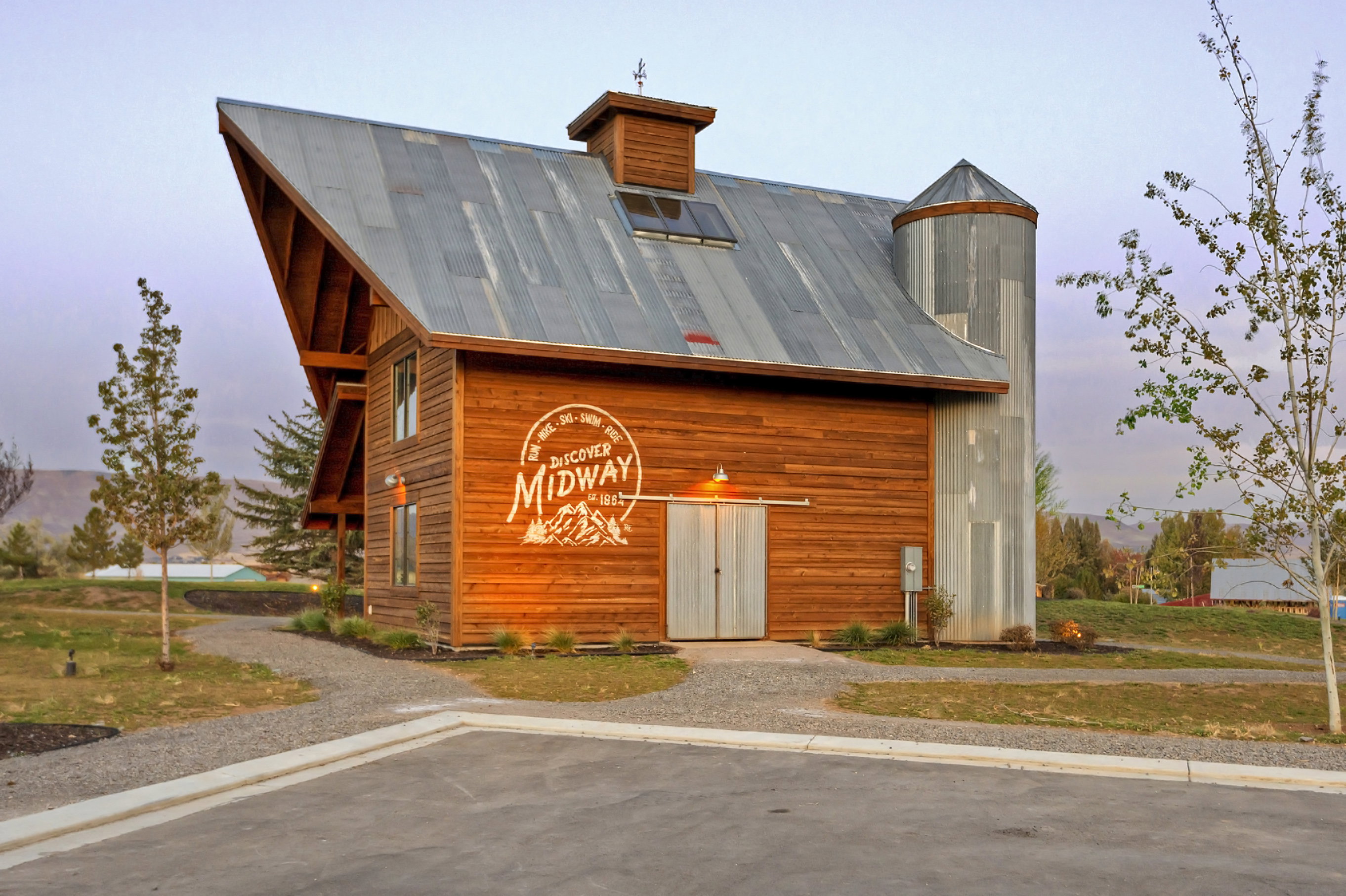 Rustic modern barn structure featuring horizontal wood siding and a corrugated metal roof