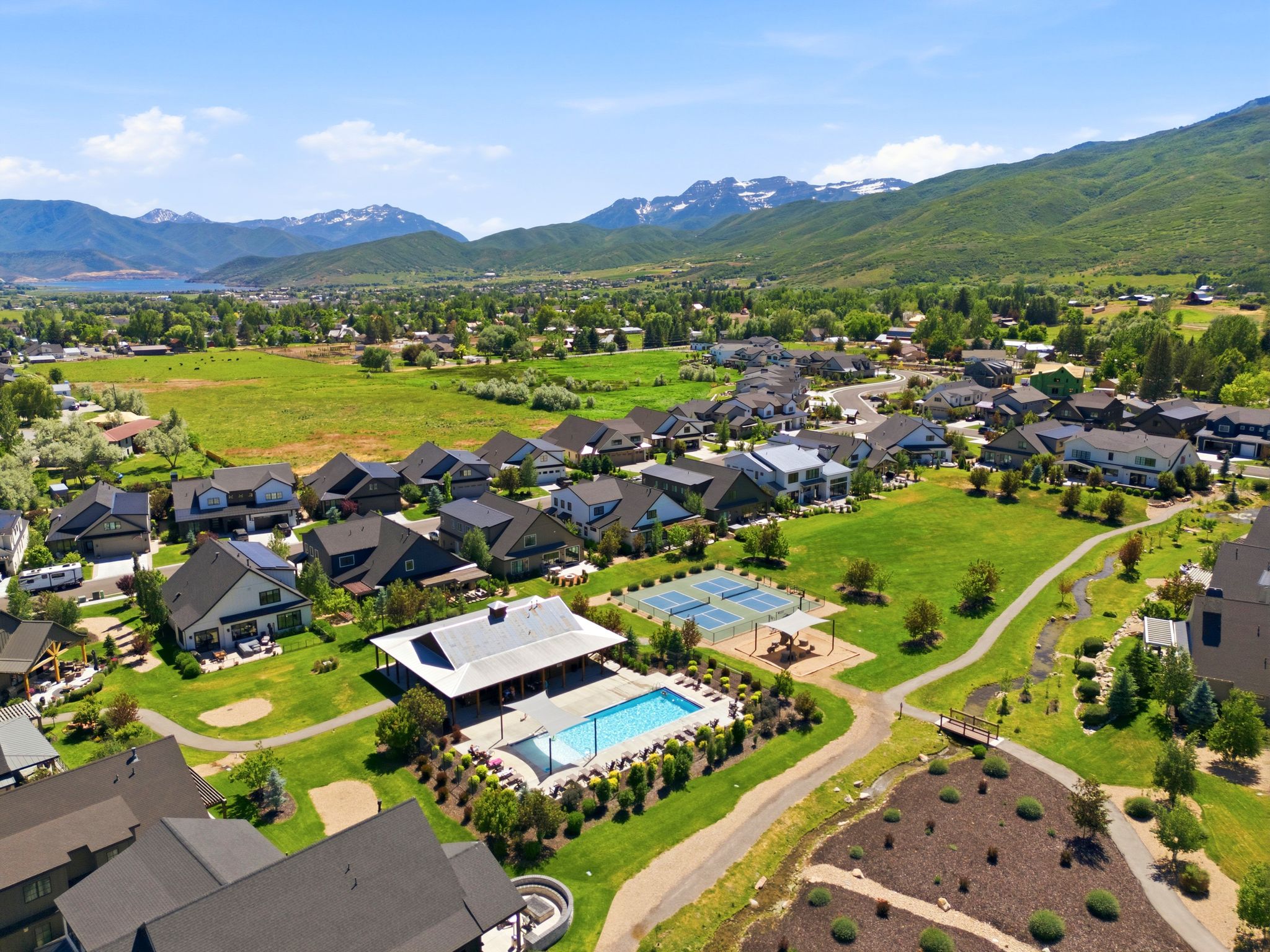 Community amenities featuring an outdoor swimming pool, covered lounge area, and tennis courts