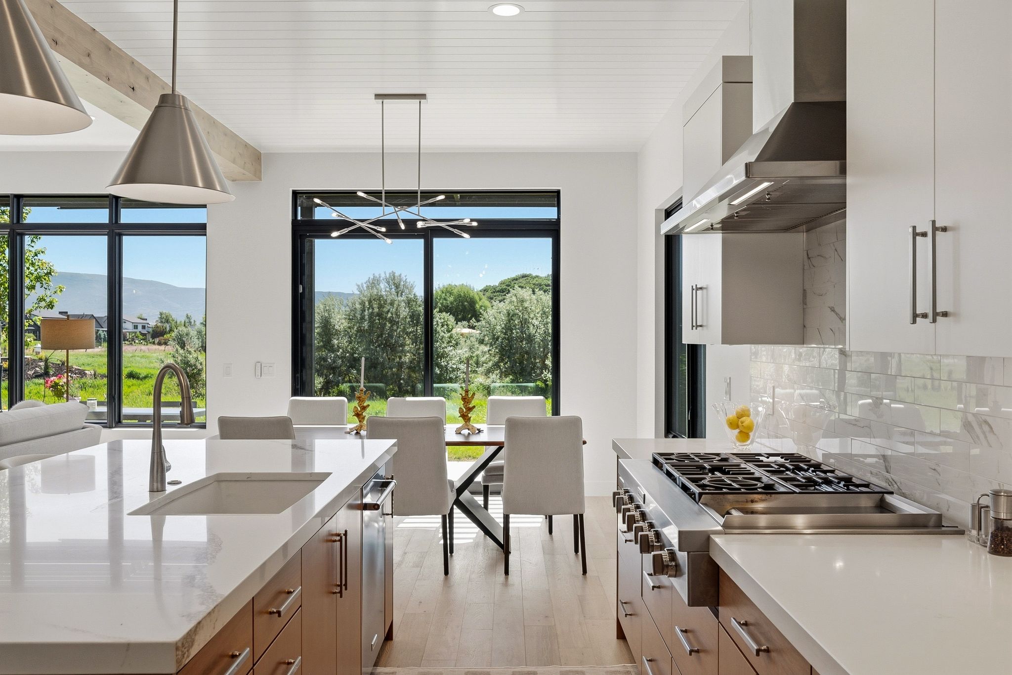 Gourmet kitchen featuring a large gas range, stainless steel appliances, and wood-finish flooring