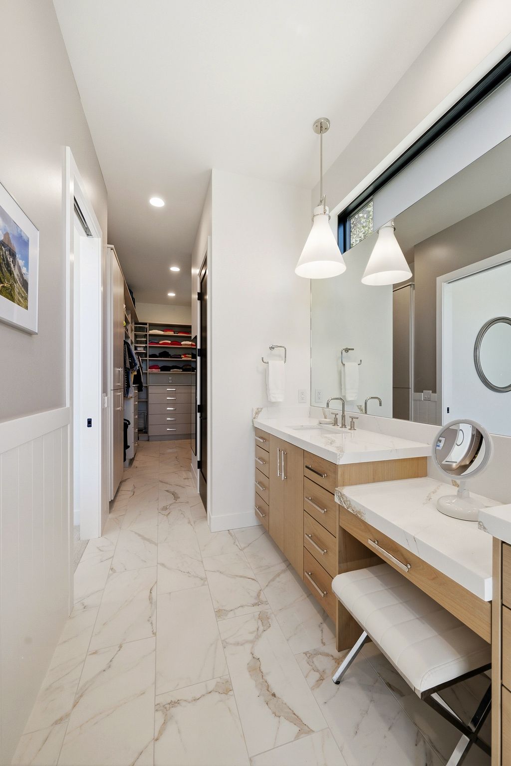 Bathroom vanity area featuring dual sinks, a built-in dressing table, and pendant lighting