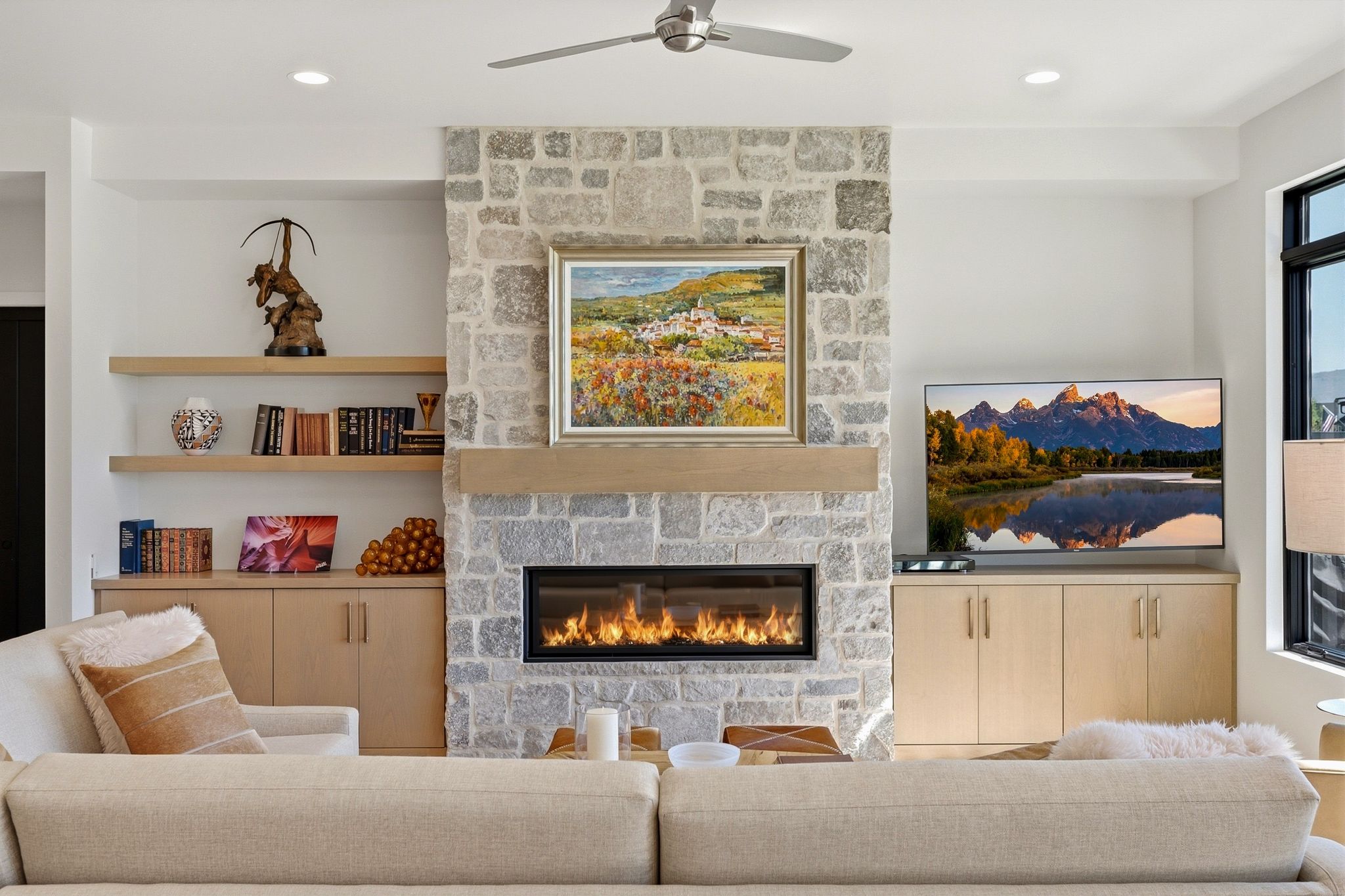 Stone-clad fireplace with a linear gas insert and a natural wood mantel