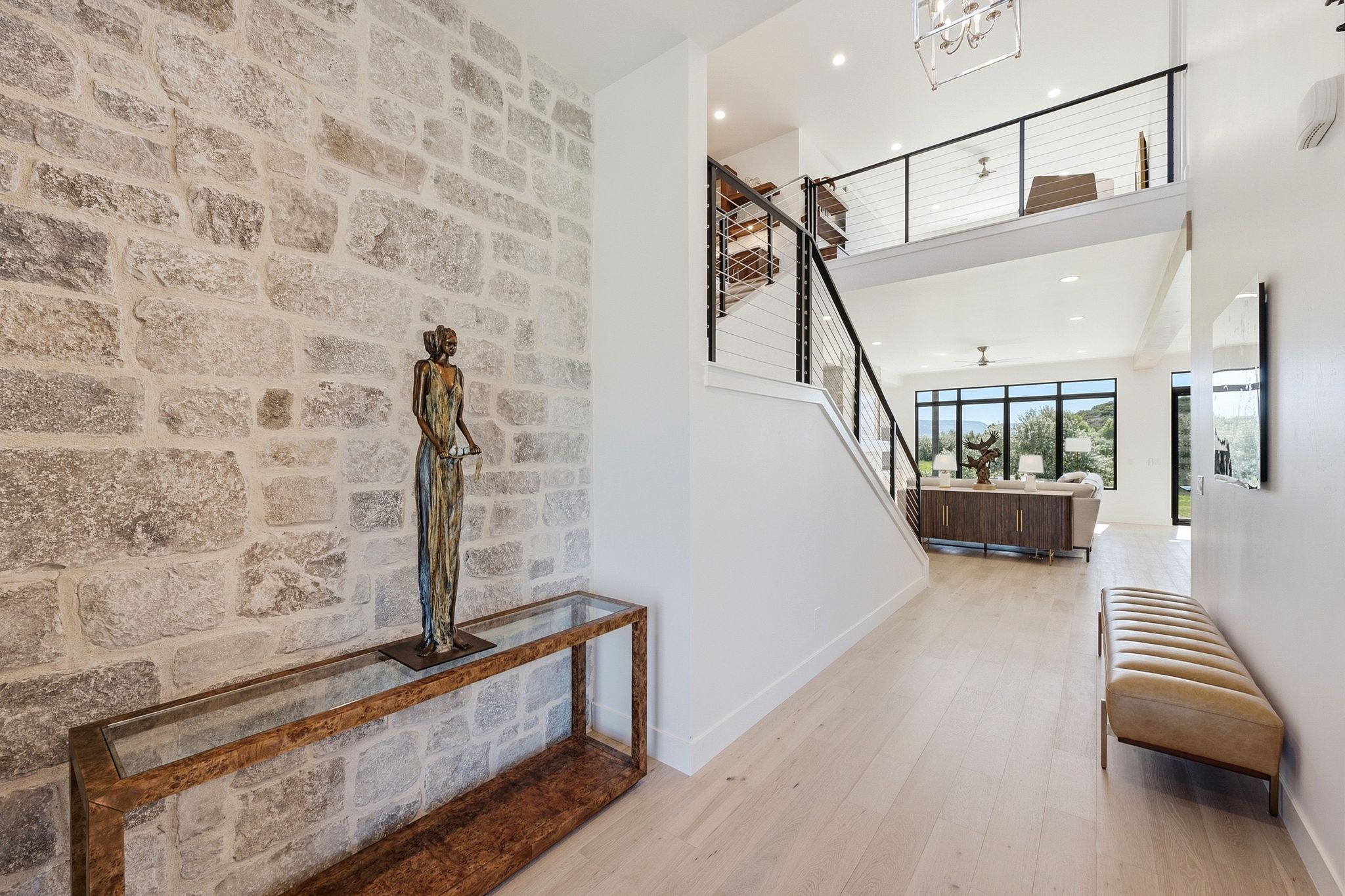 Entryway featuring a stone accent wall, light wood-finish flooring, and an open-concept design