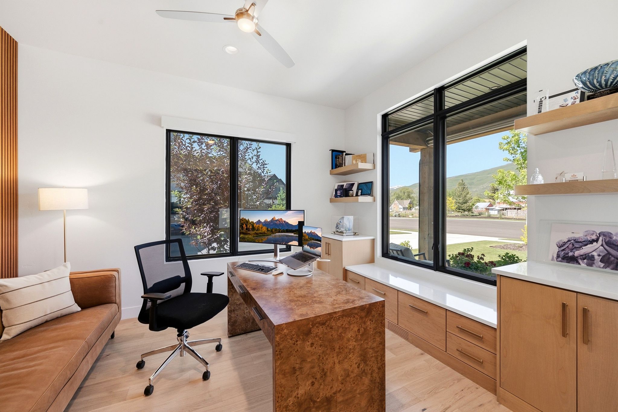 Light wood-finish flooring complements white walls with a vertical wood slat accent