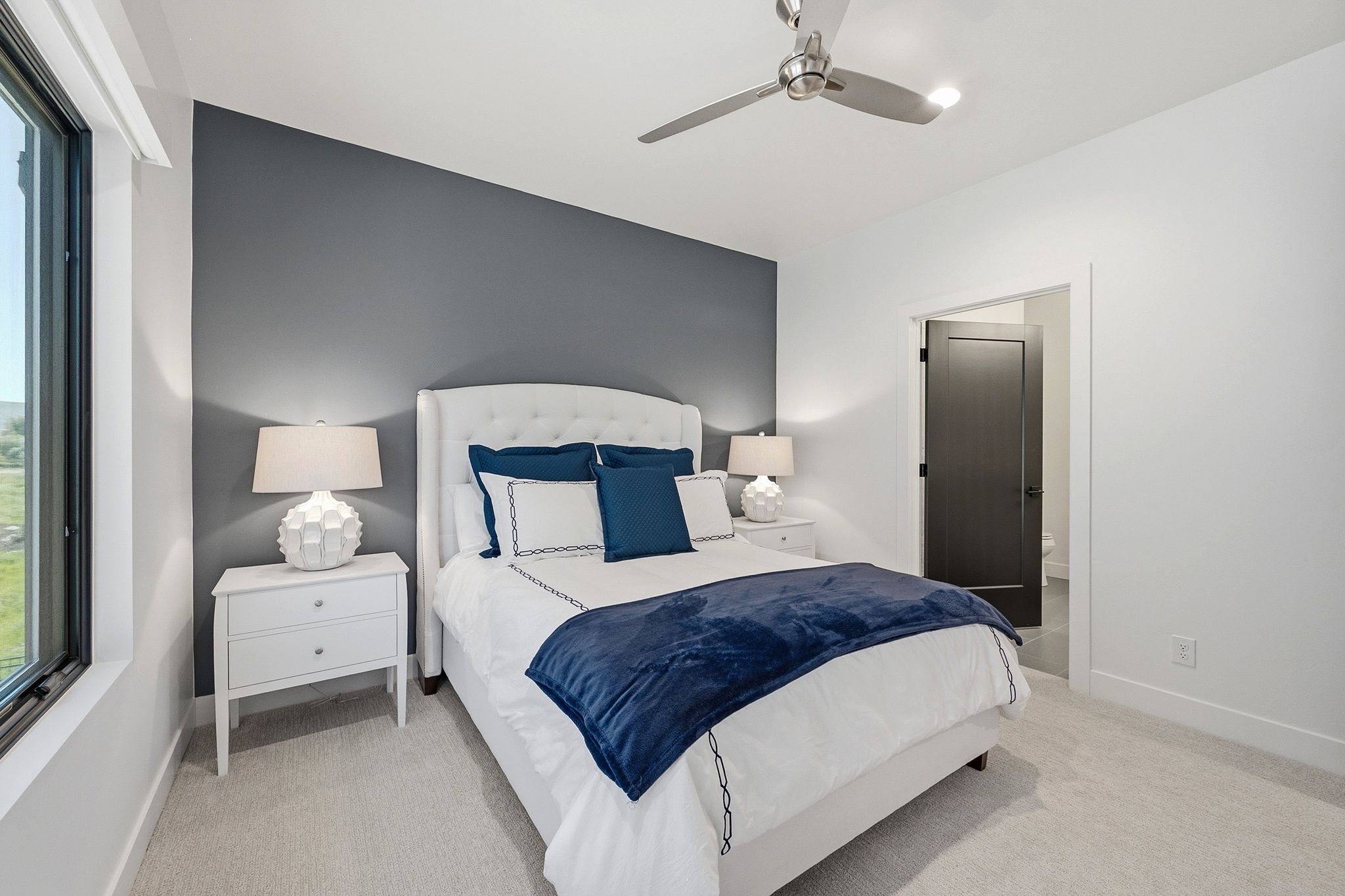 White upholstered headboard set against a contemporary accent wall