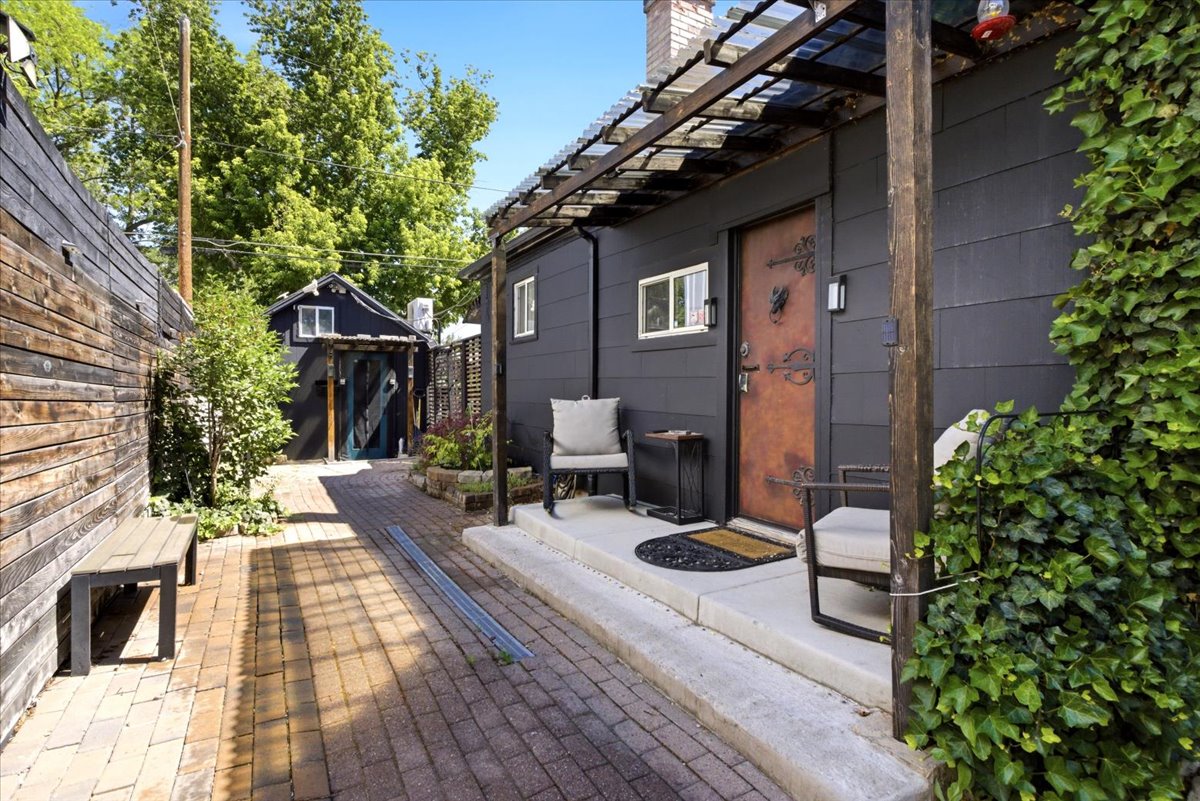 Patio area featuring brick paving, wood fencing, and an ivy-covered wall