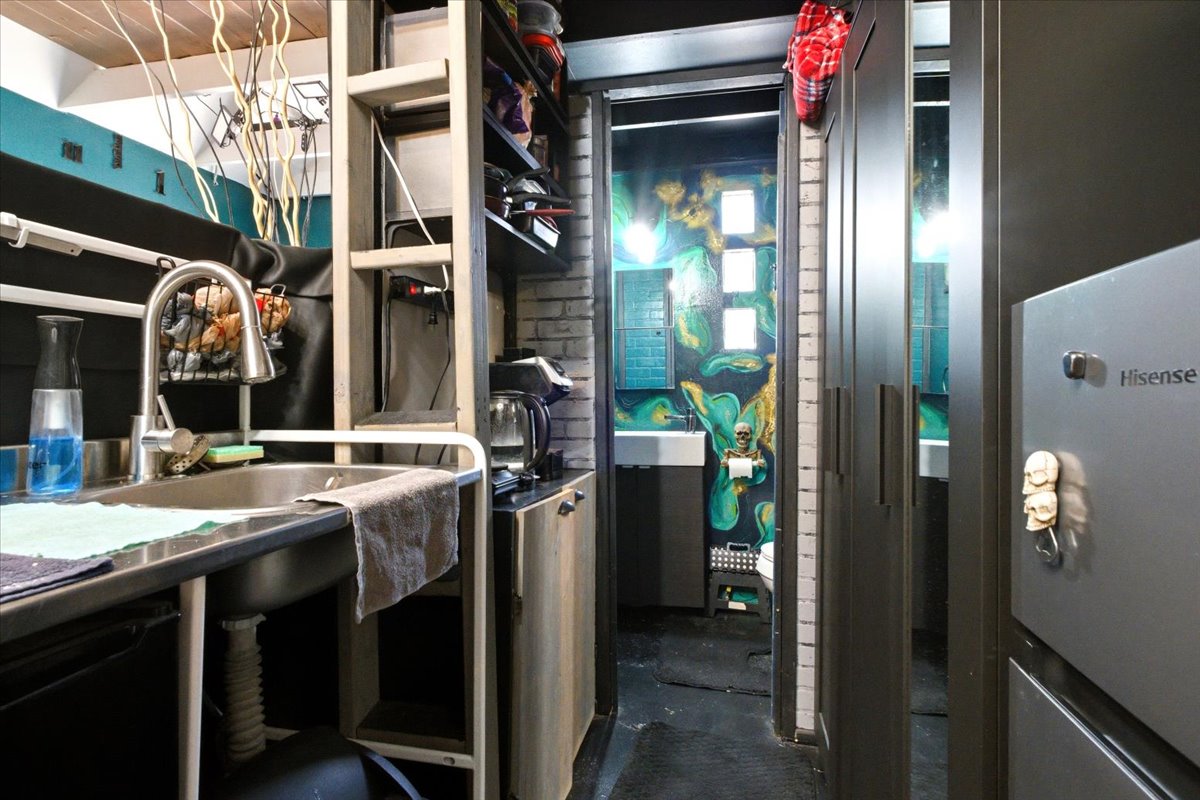 Compact kitchen area with a stainless steel sink and gooseneck faucet