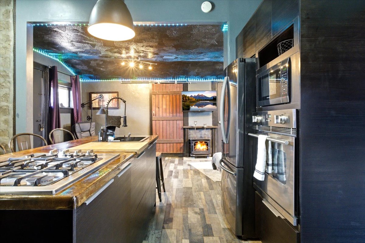 Kitchen island featuring an integrated gas cooktop and a built-in sink