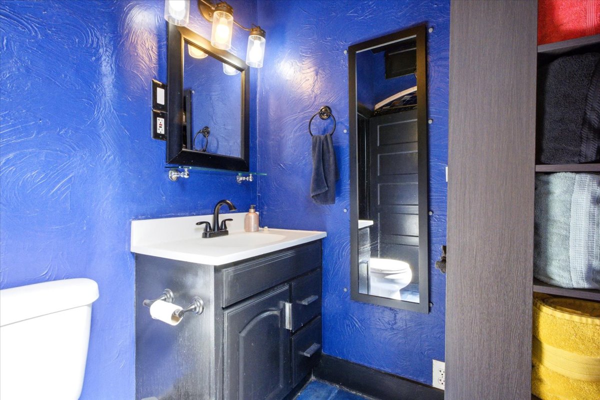 Bathroom featuring a vanity with a white countertop, dark cabinetry, and a black faucet