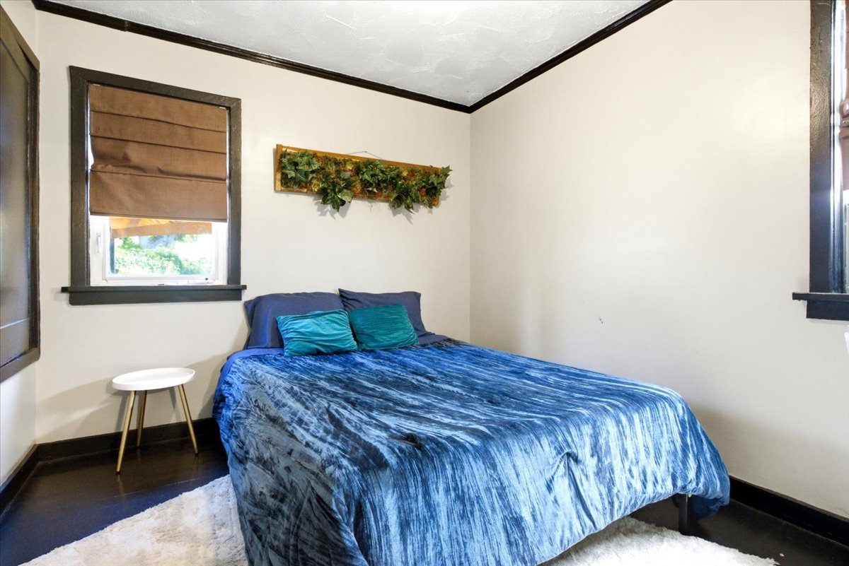 Bright room featuring dark trim, two windows with window treatments, and high ceilings