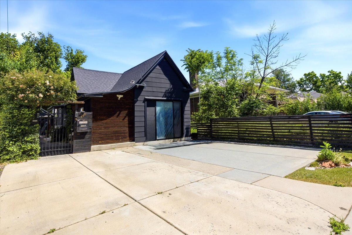 Modern-style exterior featuring dark siding, a gabled roof, and a prominent sliding glass door