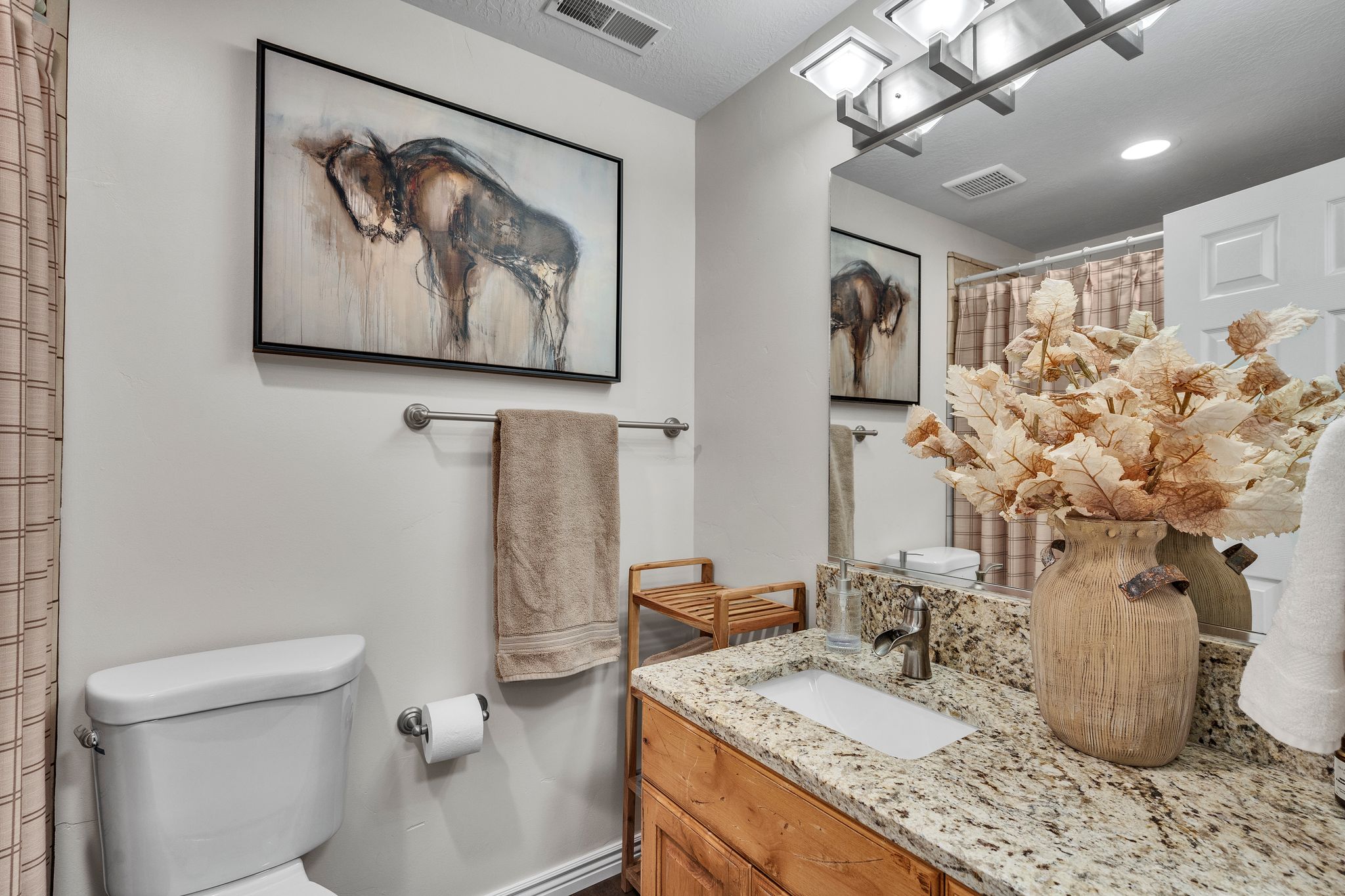 Bathroom featuring a light-toned vanity with an integrated sink and granite-finish countertop