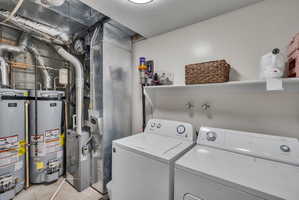 Dedicated utility area featuring a top-load washing machine, front-load dryer, and wall-mounted shelving