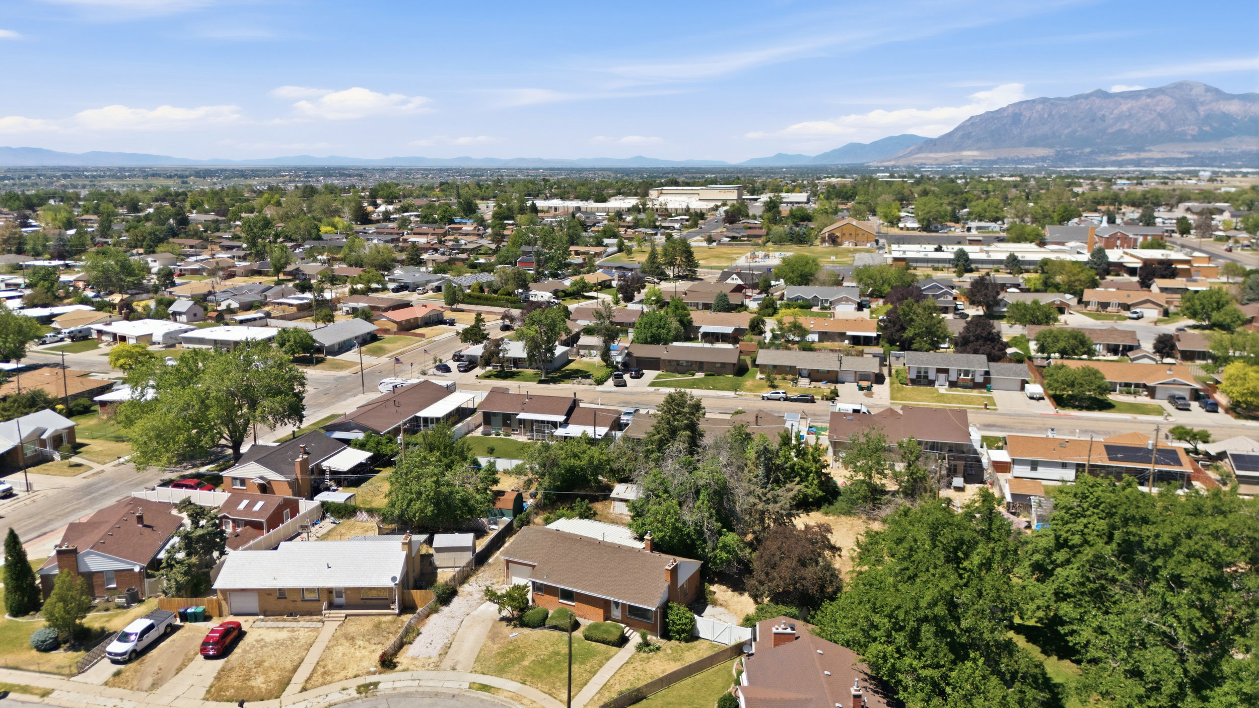 Expansive aerial view of a residential neighborhood with a distant mountain range backdrop