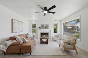Living area featuring a fireplace with a white mantel, ceiling fan, recessed lighting, and large picture windows