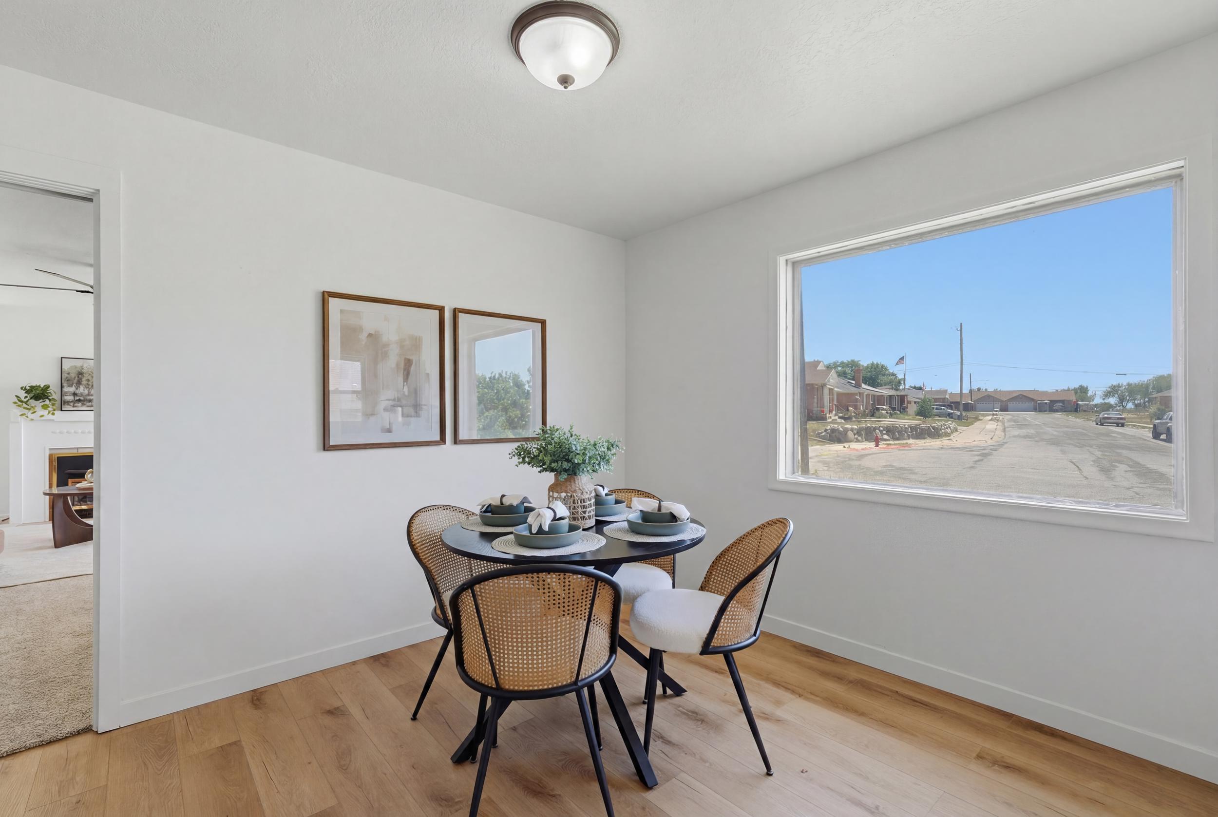 Dining area featuring wood-finish flooring, white baseboards, a large picture window, and a ceiling-mounted light fixture