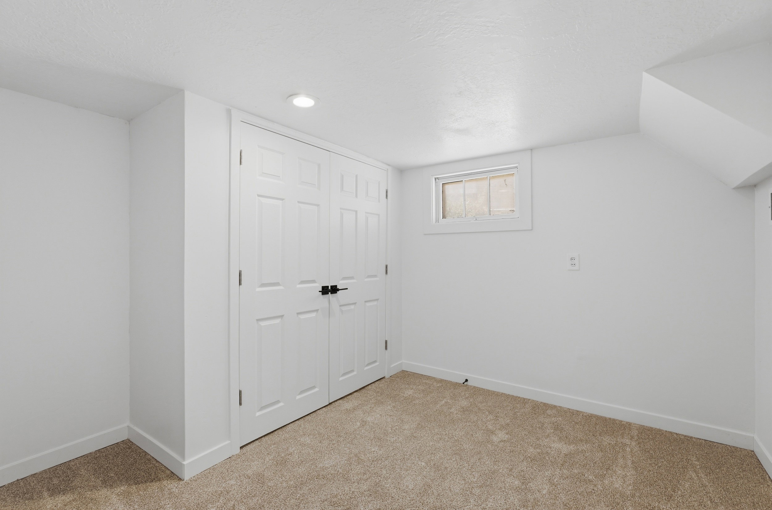 Neutral-toned carpet flooring and white walls