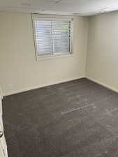 Bedroom featuring neutral wall paint, white trim, gray carpet flooring, and a window with blinds