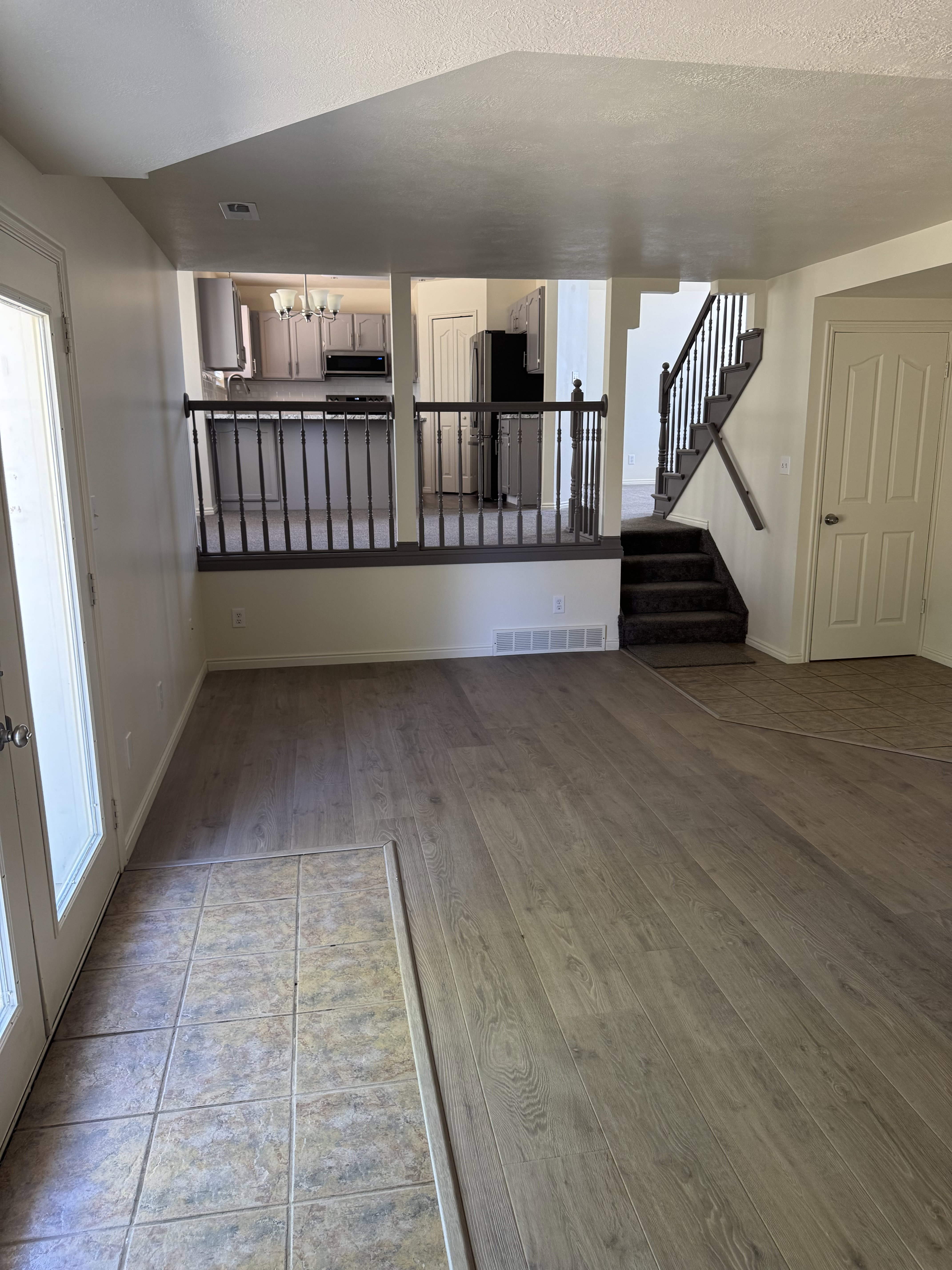 Open-concept living area featuring wood-finish flooring and a tiled entry