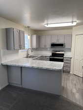 Kitchen featuring gray cabinetry, white subway tile backsplash, and light-toned countertops