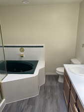 Corner soaking tub with white tile surround and green accent trim