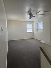 Carpeted room featuring multiple windows with blinds, a ceiling fan with integrated lighting, and neutral wall tones