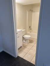 Bathroom featuring a white vanity cabinet, a white toilet, and a white bathtub with an integrated shower