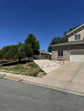 Exterior featuring brick and siding facade, an attached garage, and a concrete driveway