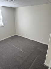 Neutral wall finishes complement the dark gray carpeting