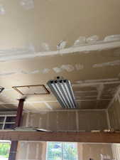 Exposed wood beam supporting an upper-level floor with a red support column