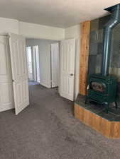 Freestanding wood-burning stove with a green finish, set on a slate hearth with a wood-paneled base