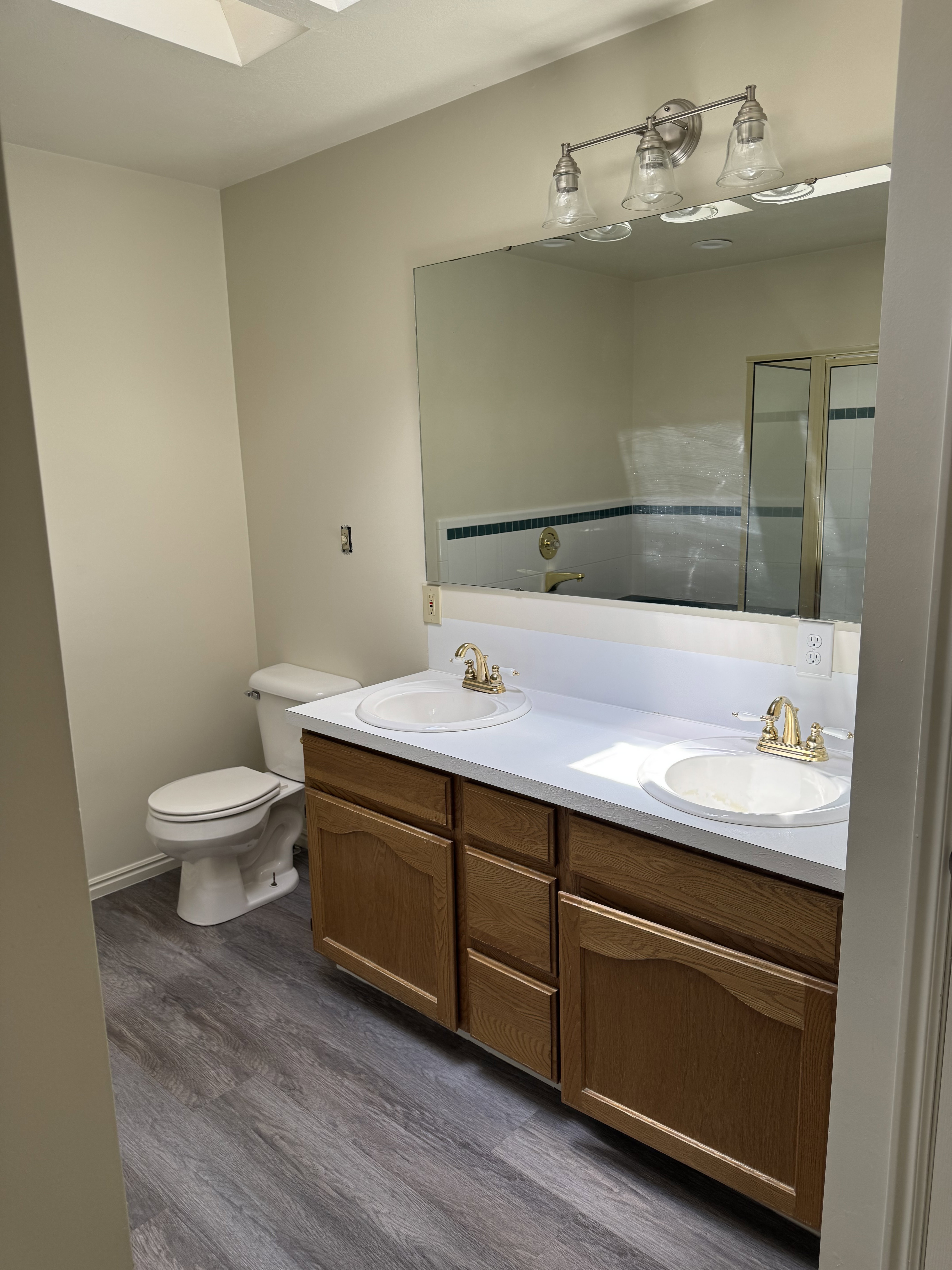 Dual vanity featuring white countertops, undermount sinks, and gold-tone fixtures