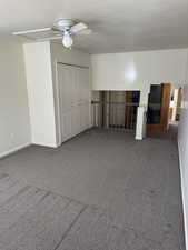 Carpeted room featuring a ceiling fan with light, bi-fold closet doors, and painted baseboards