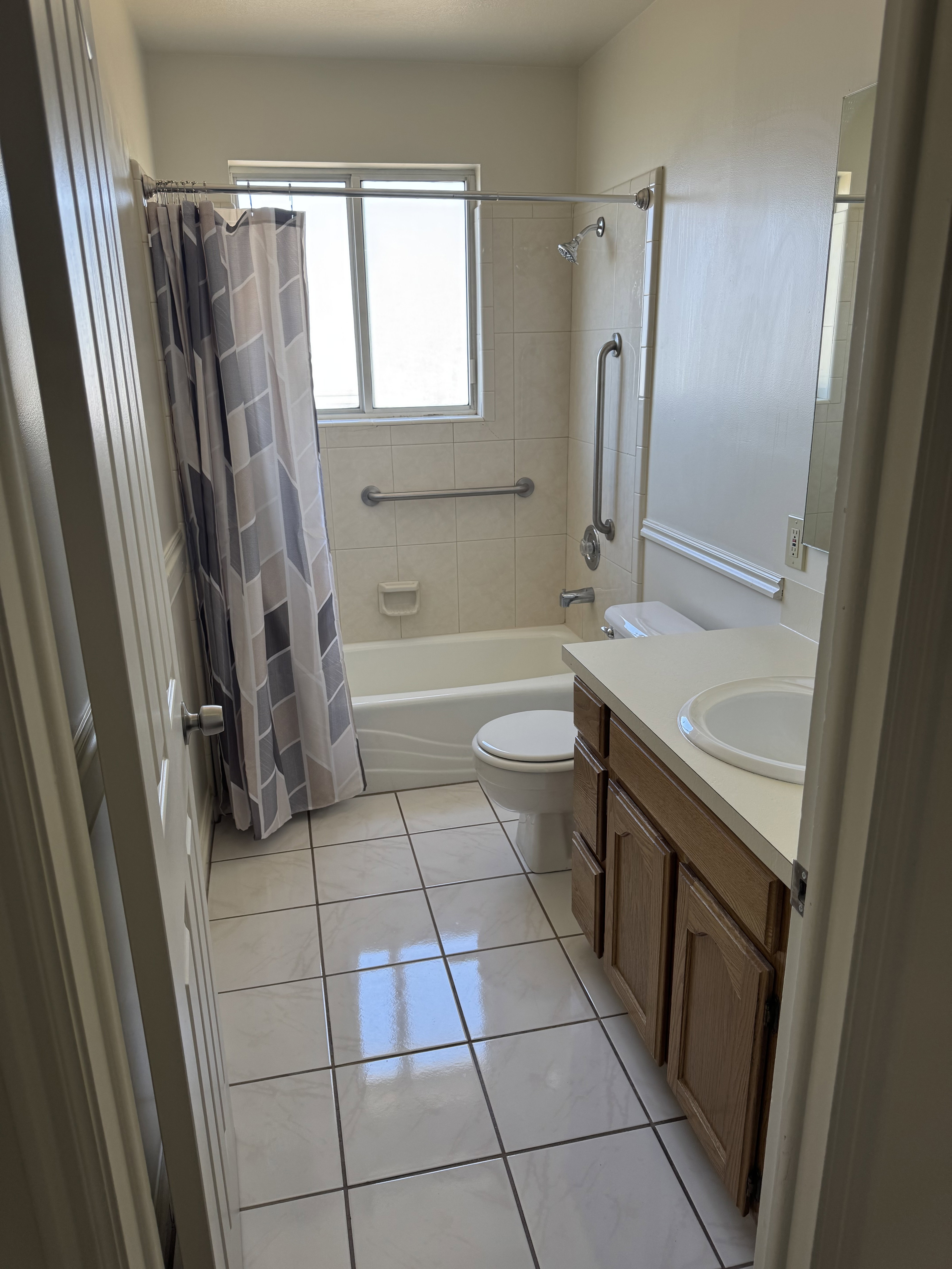Bathroom featuring a single-sink vanity with wood-finish cabinetry, a white countertop, and a white toilet