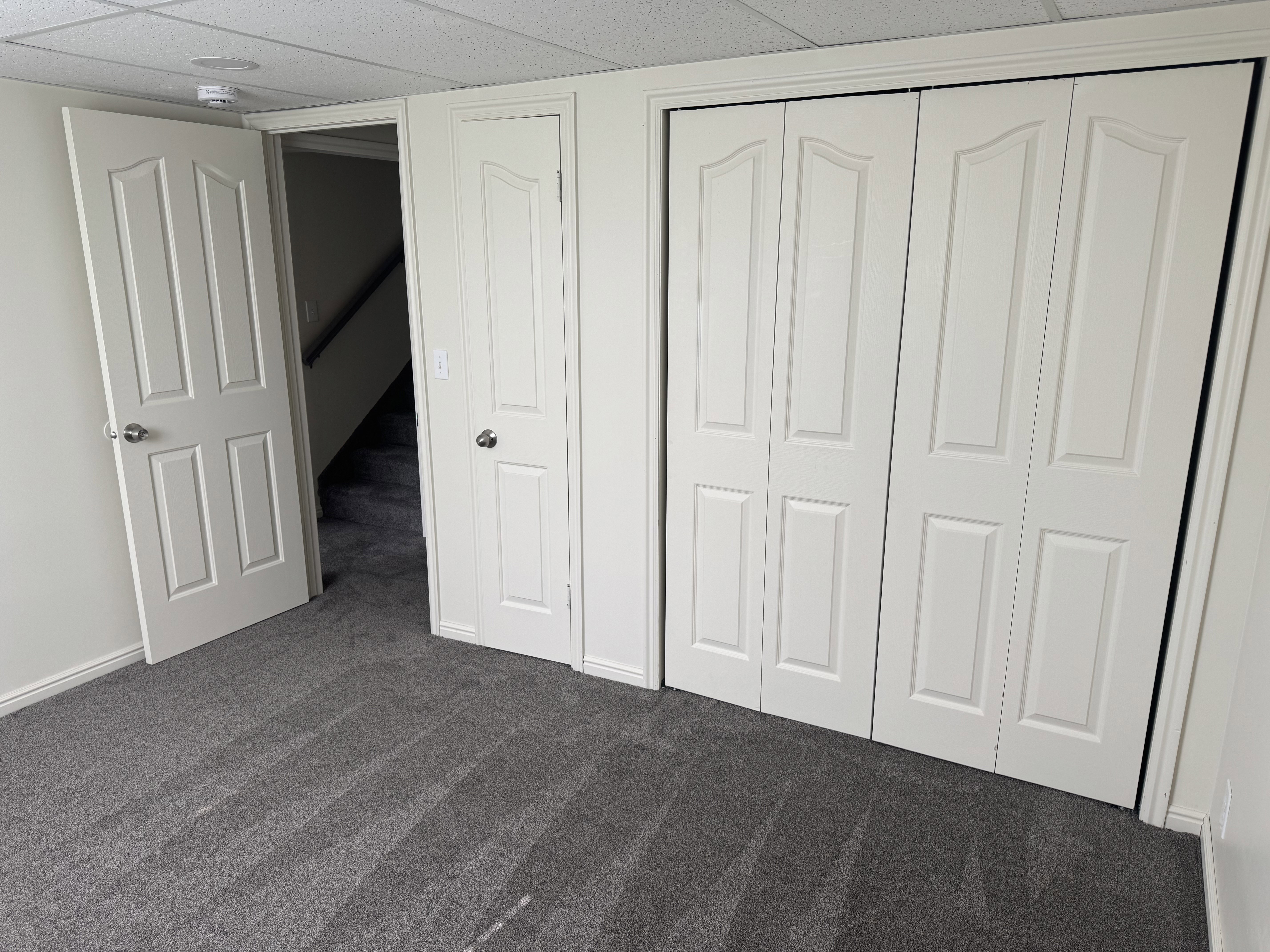Gray textured carpeting complements the neutral wall color