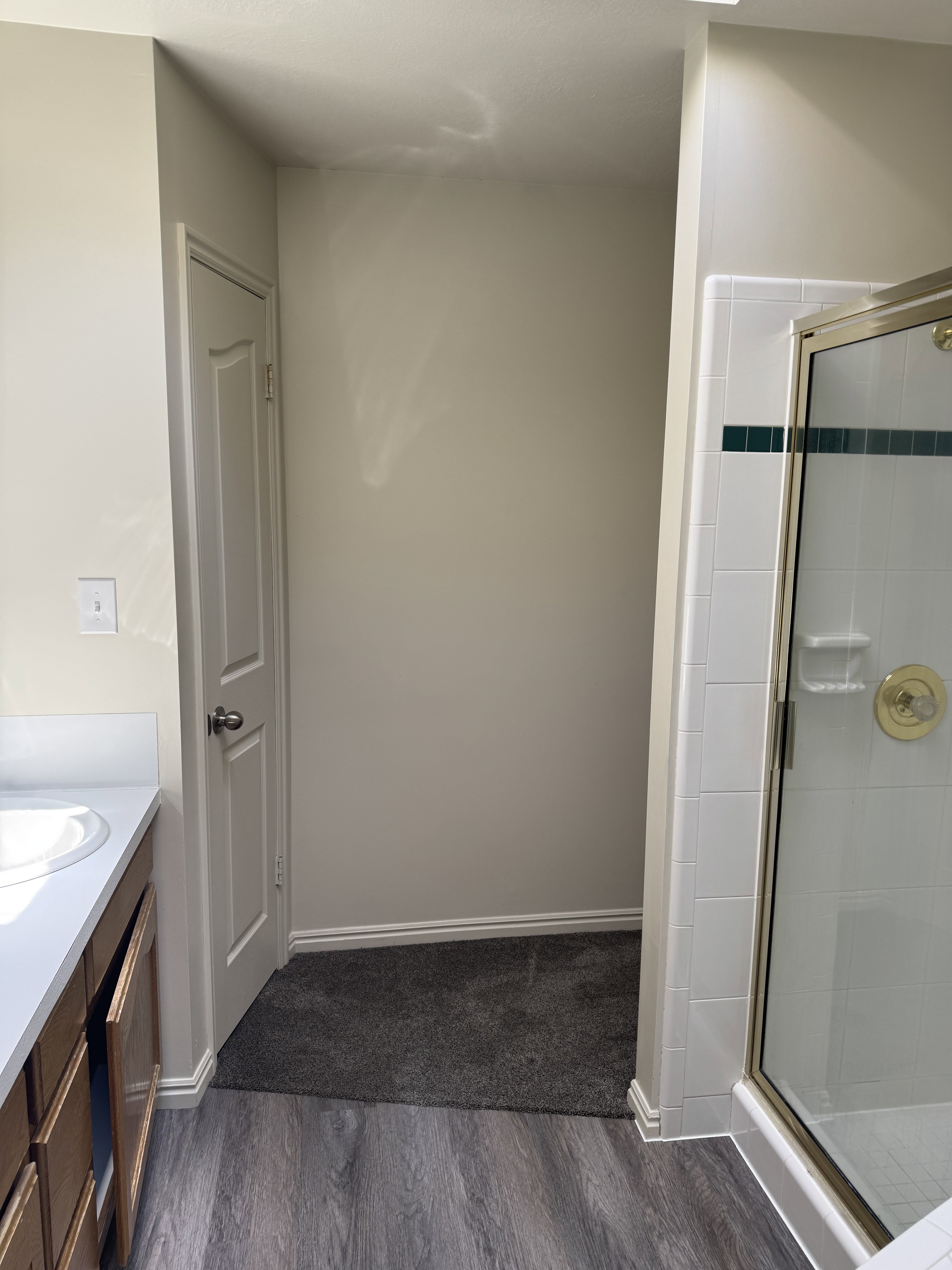 Bathroom featuring a single vanity with an undermount sink, wood-finish cabinetry, and a white countertop