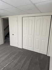 Recessed lighting illuminating a plush gray carpeted room with white bi-fold closet doors and a white paneled door