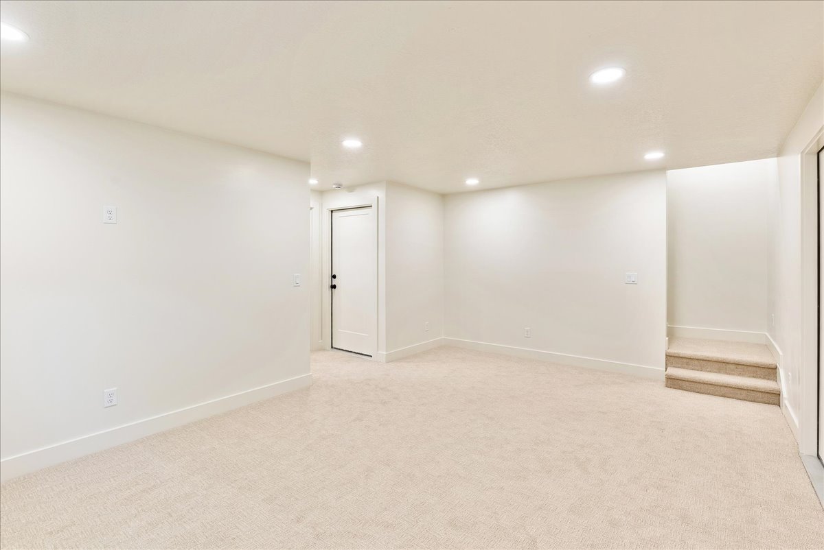Spacious room featuring neutral carpeting, recessed lighting, white walls, and bright white trim