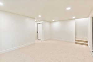 Spacious room featuring neutral carpeting, recessed lighting, white walls, and bright white trim