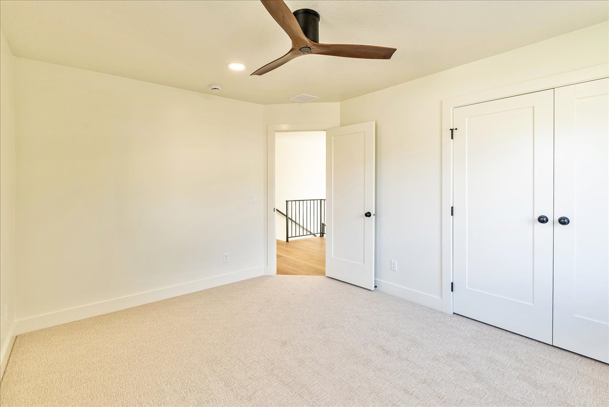 Neutral tone wall color, recessed lighting, and a modern ceiling fan