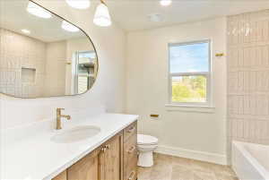 Bathroom featuring a wood-finish vanity with a white countertop and undermount sink