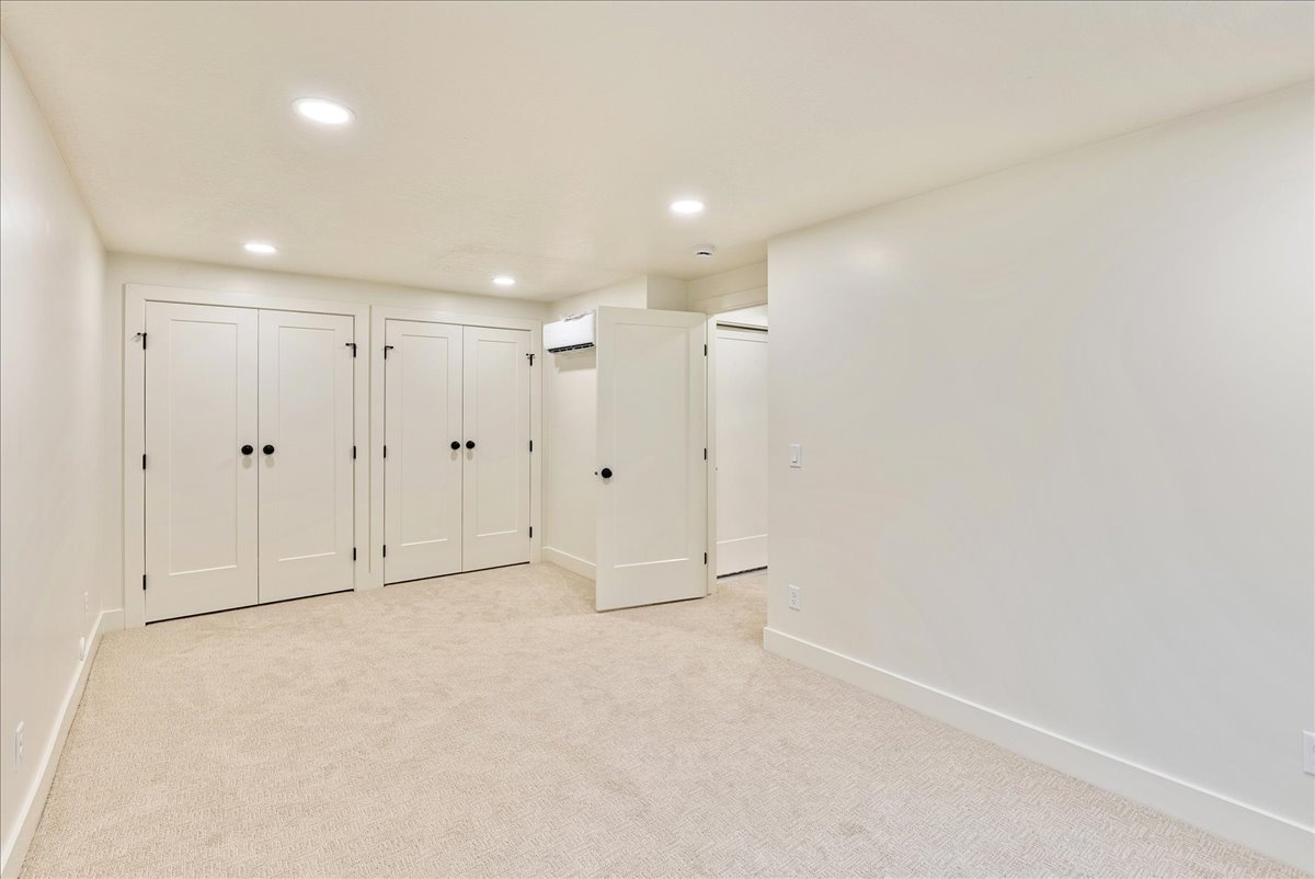 Neutral-toned carpeting and recessed ceiling lighting complement the light wall finishes