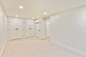 Neutral-toned carpeting and recessed ceiling lighting complement the light wall finishes