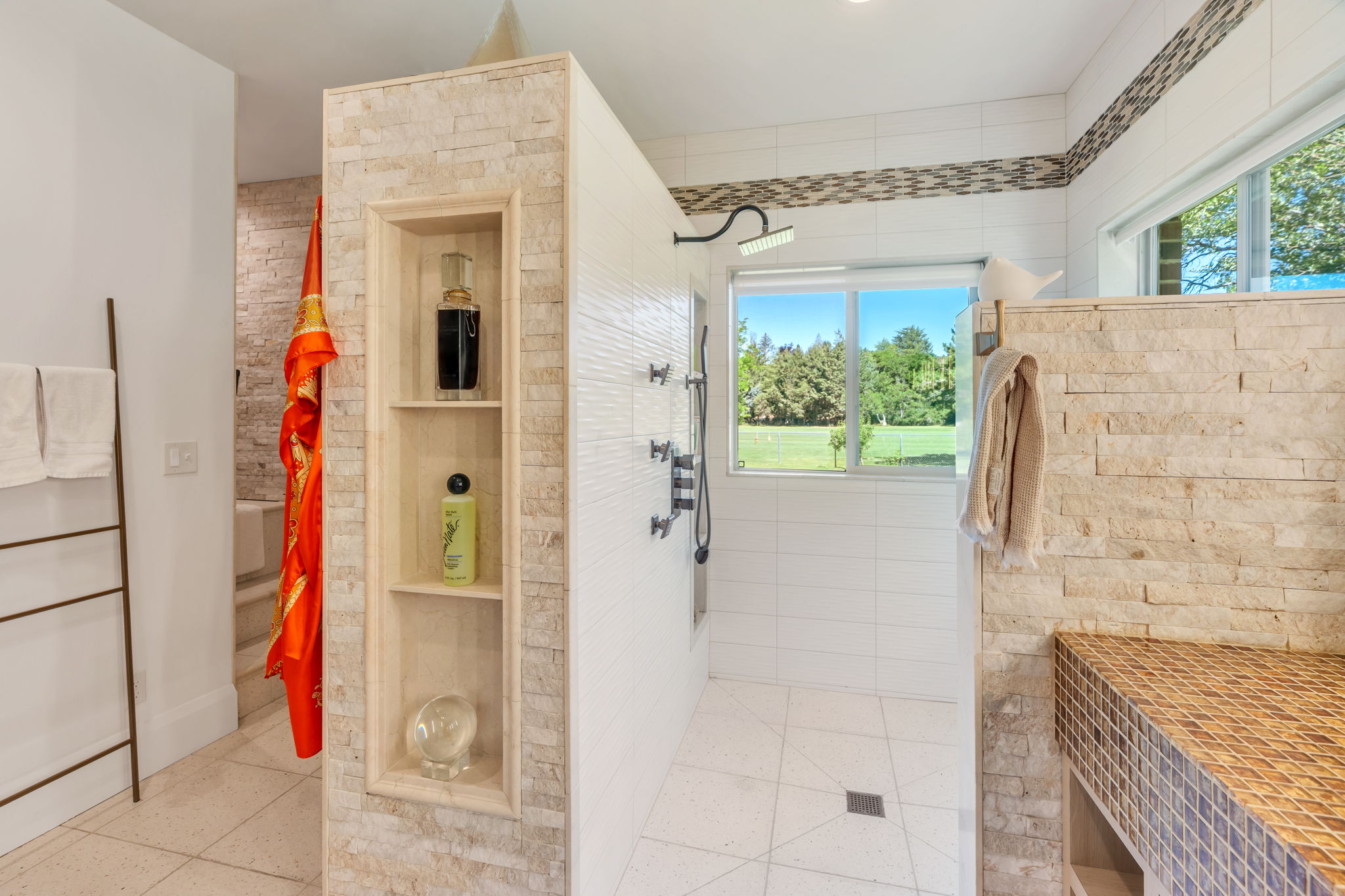 Walk-in shower with a rainfall showerhead and a tiled bench