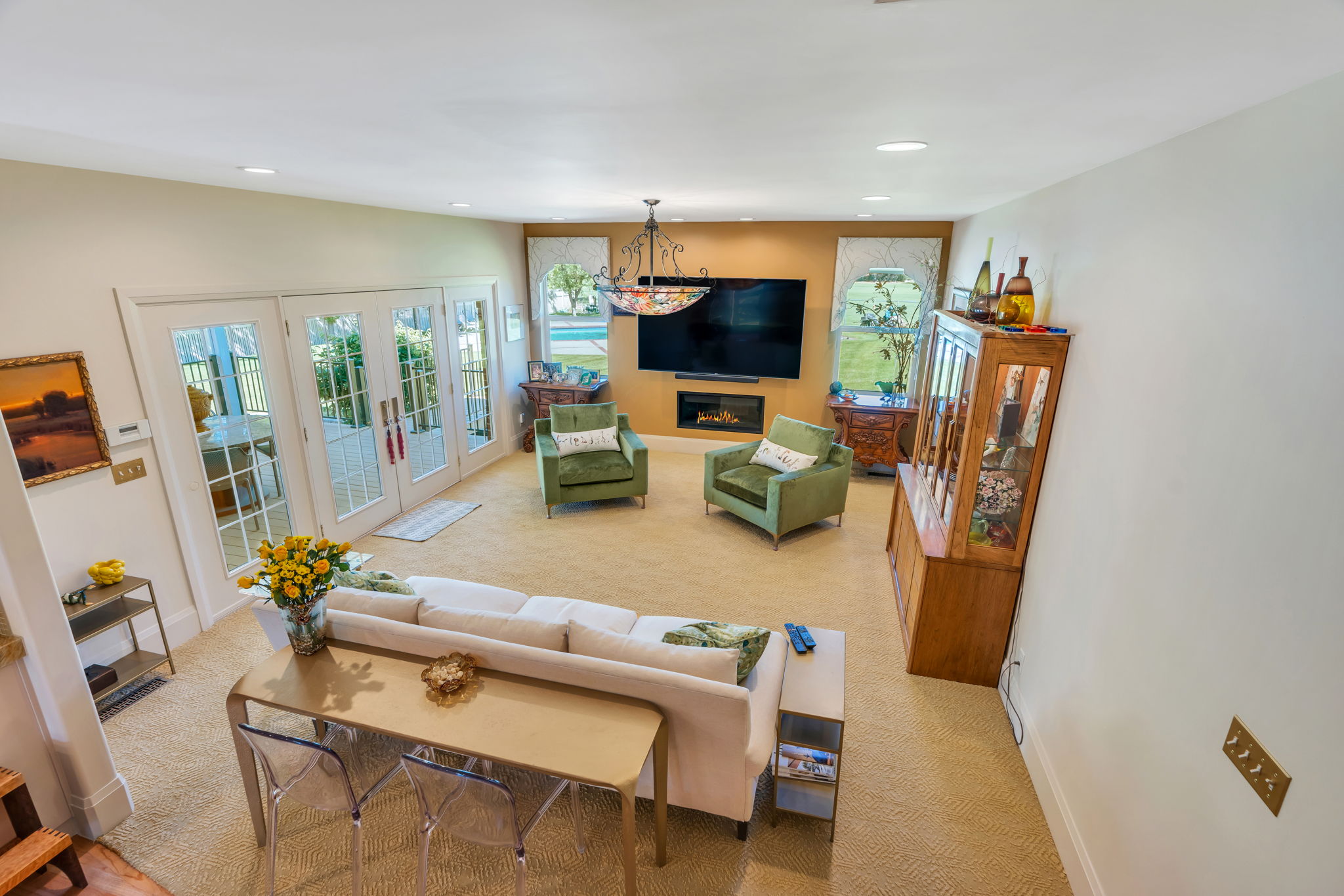 Spacious living area featuring light-toned carpeting and recessed lighting