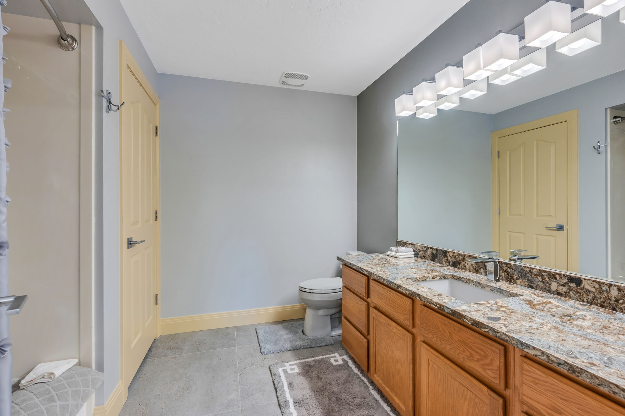 Bathroom vanity featuring a single undermount sink, a chrome faucet, and a stone countertop