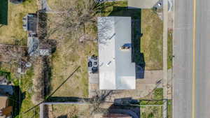 Overhead property perspective featuring a light-colored roof, multiple outbuildings, and a concrete driveway