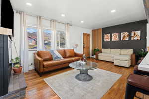 Spacious living area featuring wood-finish flooring, recessed lighting, and multiple windows