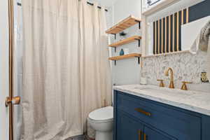 Bathroom featuring a blue vanity with gold-tone hardware, a white countertop with an integrated sink, and a gold-tone faucet