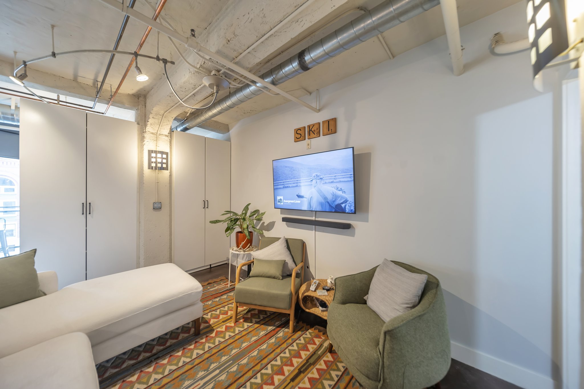 Industrial-style living space featuring exposed ductwork and concrete ceilings